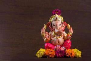 Hindu God Ganesha. Ganesha Idol on dark wooden background. photo