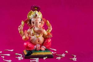 Hindu God Ganesha. Ganesha Idol on pink background. photo