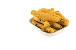 Dry Turmeric roots or barks in white plate isolated on white background photo