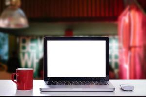 Front view of cup and laptop, smartphone, and tablet on table in office photo