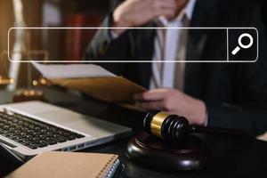 Searching Browsing Internet Data Information Networking Concept with blank search bar.justice and law concept.Male judge in a courtroom with the gavel,working with digital tablet computer. photo