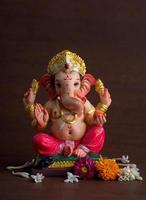 Hindu God Ganesha. Ganesha Idol on dark wooden background. photo