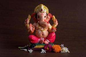 Hindu God Ganesha. Ganesha Idol on dark wooden background. photo