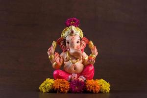 Hindu God Ganesha. Ganesha Idol on dark wooden background. photo