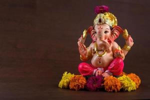 Hindu God Ganesha. Ganesha Idol on dark wooden background. photo