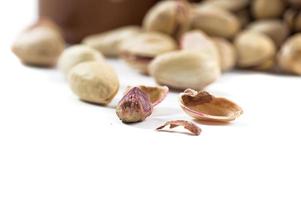 Pistachio and Cashew Nuts in clay pots on white background photo