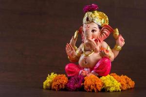 Hindu God Ganesha. Ganesha Idol on dark wooden background. photo