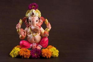 Hindu God Ganesha. Ganesha Idol on dark wooden background. photo