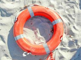 Orange life buoy on the shore photo