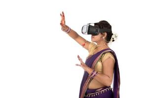 Indian traditional young woman in saree looking though VR device photo