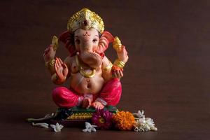 Hindu God Ganesha. Ganesha Idol on dark wooden background. photo