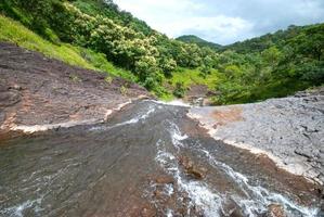 paisaje con montañas, árboles y un río en frente. foto