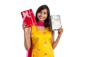 Portrait of young happy smiling Indian Girl holding gift boxes on a white background. photo