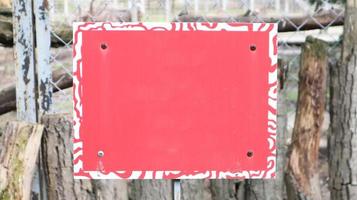 Red blank metallic signboard on a fence for artwork template design. blank form. Copy space for your text or logo. photo