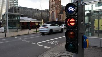 Dusseldorf, Germany - February 28, 2020. traffic light for bicycles close-up with a busy city in the background at a crossroads in Germany. Cyclists wait for a traffic light to cross the street.