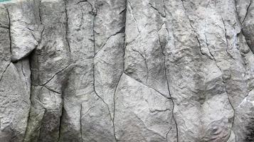 Stone rock texture or background. Gray rocky uneven surface, natural seamless backdrop for design. Copy space photo