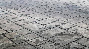 Concrete or cobblestone gray paving slabs or stones for the floor. Pavement in the city. Large gray paving tiles close up. photo