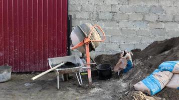 Hormigonera móvil por gravedad con autodescarga color naranja que prepara mortero de cemento. máquina de construcción móvil para la preparación de mezclas de hormigón. mezcla de productos a granel. foto