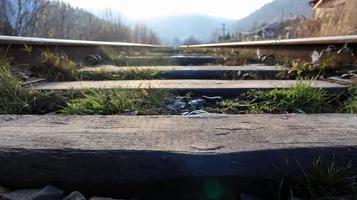 Close Up perspective view of railway tracks on a bright sunny day. Rails and wooden sleepers in oil with crushed stone. low down view of railway train transport metal steel rails. photo