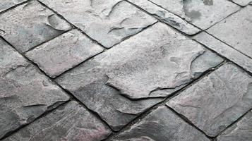 Concrete or cobblestone gray paving slabs or stones for the floor. Pavement in the city. Large gray paving tiles close up. photo