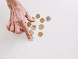 senior hands counting euro coins on the table. poverty, crisis, deposit, recession concept photo