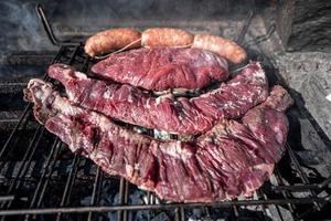 Typical Uruguayan and Argentine Asado Cooked on fire. Entrana and Vacio meat cuts. Accompanied with Chorizo. photo