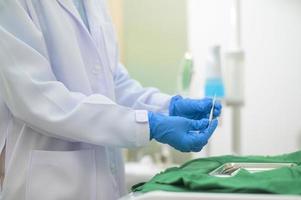 una dentista que usa guantes médicos se prepara para trabajar en una clínica dental, conceptos dentales y atención médica. foto