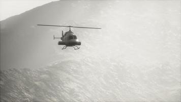 extreme slow motion flying helicopter near mountains with fog video