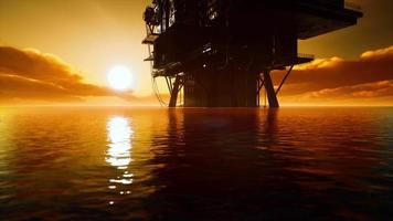 antiga plataforma de petróleo durante o pôr do sol no oceano video