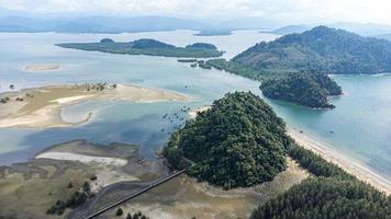 hermoso mar en el parque nacional laem son, ranong, tailandia. en el área del puerto pesquero local y en el fondo de la hermosa costa natural por vista aérea desde un dron. foto