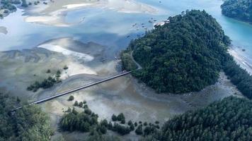 hermoso mar en el parque nacional laem son, ranong, tailandia. en el área del puerto pesquero local y en el fondo de la hermosa costa natural por vista aérea desde un dron. foto