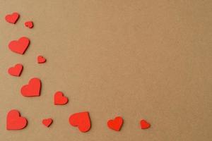 Handmade small wooden hearts. Red Hearts on kraft paper background. Love background, Valentines day photo