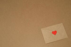 Valentine's day. Envelope with red heart on a background of kraft paper, copy space. February 14th photo