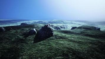 piedra de arena grande y fondo de colina de hierba verde foto