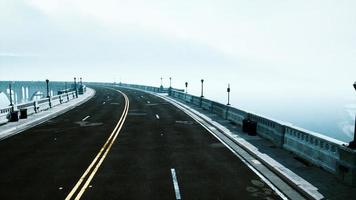 Asphalt highway and mountain in deep fog photo