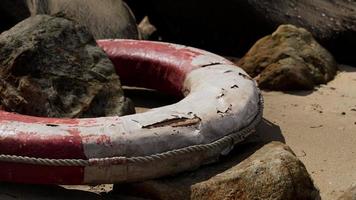 old Life Buoy on sand in sunset photo