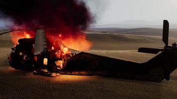 burned military helicopter in the desert at sunset photo