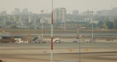 una vista della pista dell'aeroporto con edifici sullo sfondo, in tempo reale video