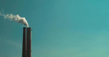 fumaça saindo de uma chaminé de usina de carvão contra o céu azul, câmera lenta video