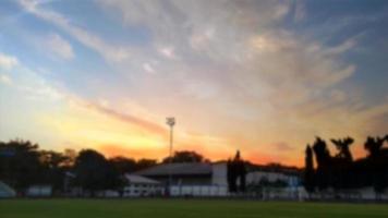 paisaje desenfocado de un campo de fútbol con una hermosa puesta de sol. copiar espacio de texto. foto