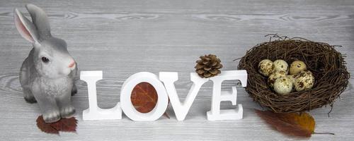 Wooden letters of the alphabet in the form of the words LOVE on a light background. Word love, easter bunny and easter eggs. Selective focus. photo