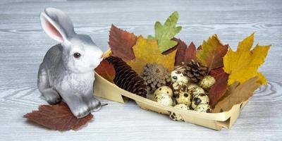 Easter Bunny, Easter eggs in a wicker basket. Spring composition on a light background. photo