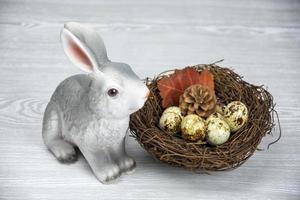 Easter Bunny and Easter eggs in the nest. Spring composition on a light background. photo