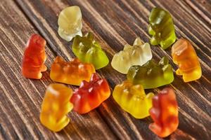 Multicolored bears gummy candy on wooden vintage background. Jelly candies of different colors