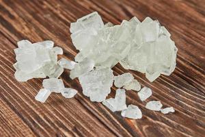 Crystalline sugar lying on vintage wooden background photo