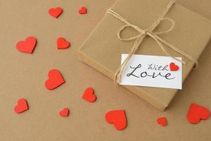 Love, Valentines Day banner. Kraft paper gift box, With love text card, red hearts shaped confetti photo