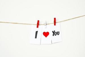 tarjeta de san valentín con texto te amo colgando de una cuerda con pinzas para la ropa. 14 de febrero, concepto foto