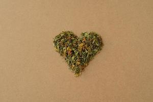 Green heart of dried flowers and St. John's wort leaves. Love herbal tea. Dry Medicinal plant tutsan photo
