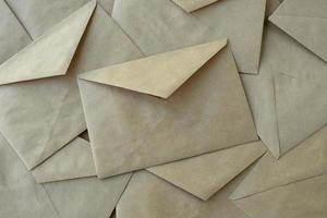 envelope background, lots of brown kraft paper envelopes on the table, top view photo