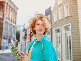 redhead young woman travel over West Europe and using paper map in unknown town. Travel photo. Lost in new city photo